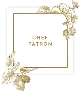 Sign saying chef patron in square with floral decorations